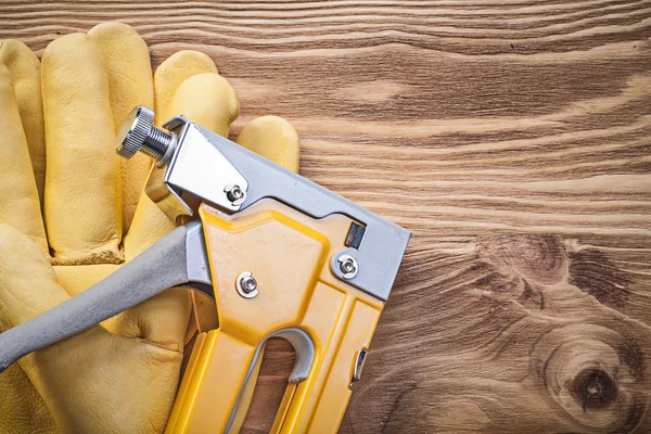 Nieten van de beschermende handschoenen pistool op houten plank bouw concep — Stockfoto