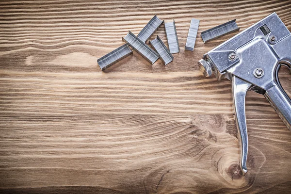 Nietmachine pistool heap van nietjes op houten plank bouwconcept — Stockfoto