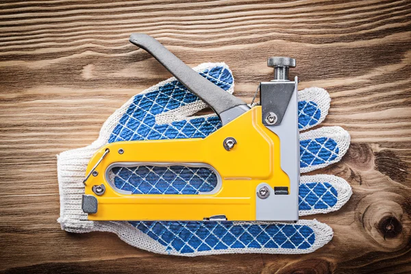 Pistola grapadora par de guantes de trabajo en la construcción de tableros de madera — Foto de Stock