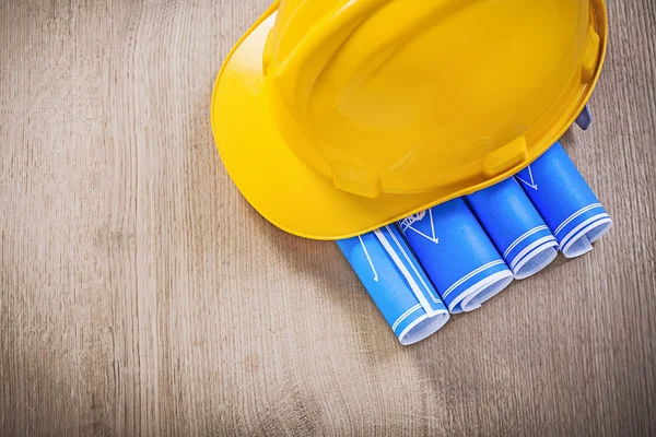 Wooden board with blue blueprints hard hat construction concept — Stock Photo, Image