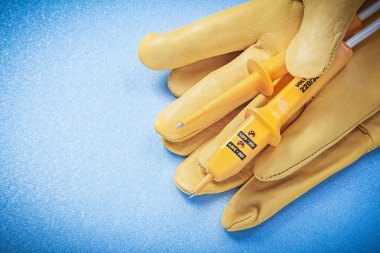 Koruyucu eldiven elektrik tester olarak mavi arka plan YYK tarihinde çifti