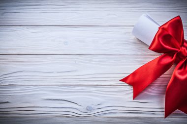 Kırmızı saten kurdele ile kağıt rulosunun ahşap tahta tatil con üzerinde