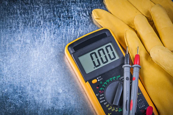 Teste de testador elétrico digital leva luvas de proteção em metálico — Fotografia de Stock