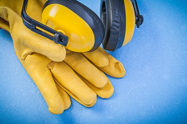 Geräuschunterdrückung Ohrenschützer Leder Schutzhandschuhe auf blauem Rücken — Stockfoto