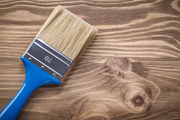 Pincel de pintura sobre tabla de madera directamente encima del concepto de construcción — Foto de Stock