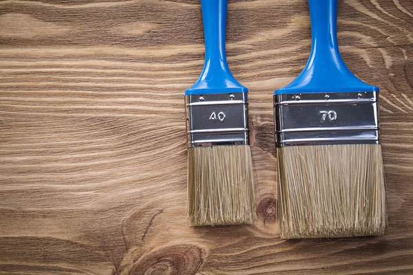 Paintbrushes on wood board top view construction concept — Stock Photo, Image