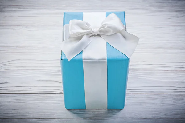 Geschenkbox mit weißer Schleife auf Holzbrett — Stockfoto