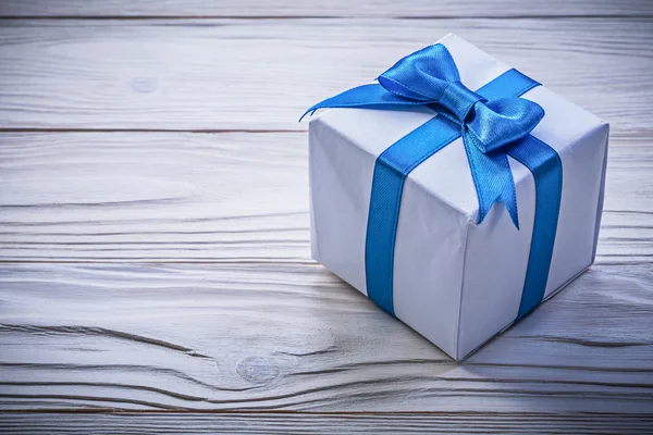 木板庆祝概念上的蓝色蝴蝶结的礼物箱 — 图库照片