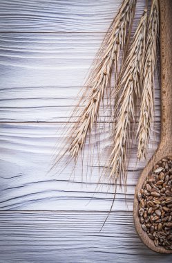 Ahşap tahta üzerinde olgun buğday ve çavdar kulakları tahta kaşık tahıl
