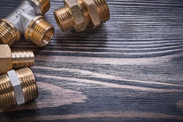 Composition of brass connectors on wooden background plumbing co — Stock Photo, Image