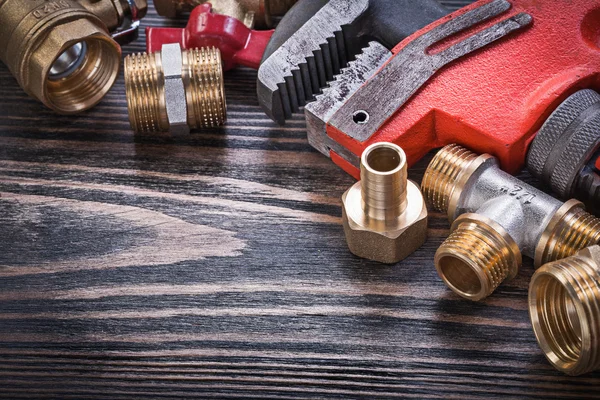 Collection of brass plumbing tools on wooden board horizontal vi — Stock Photo, Image