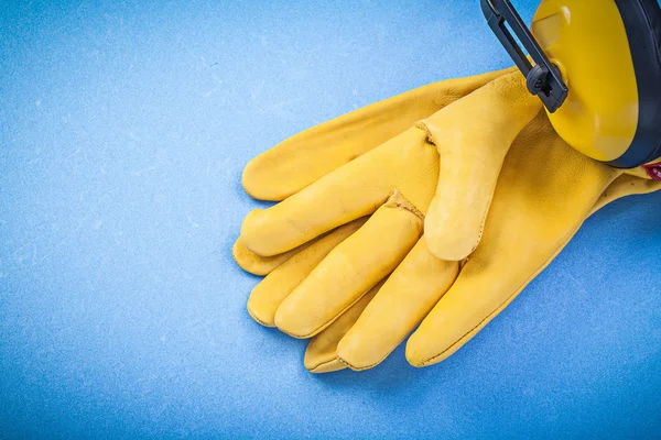 Nauszniki Skórzane rękawice ochronne na niebieskim tle budowy c — Zdjęcie stockowe