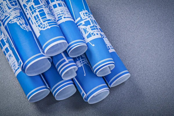 Heap de planos de construção laminados azuis em fundo cinza mainte — Fotografia de Stock