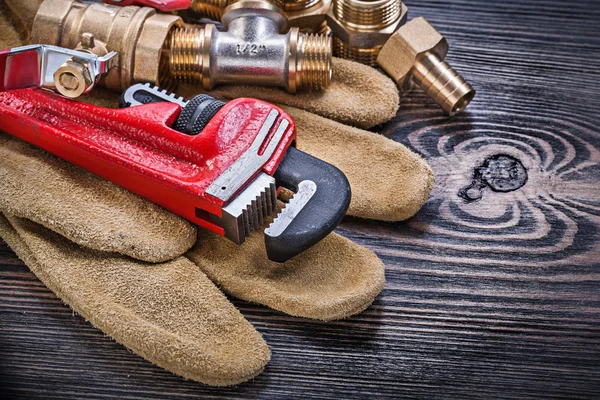 Leather safety gloves monkey wrench brass plumbing connectors ba — Stock Photo, Image