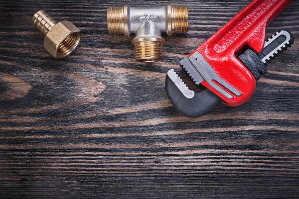 Monkey wrench brass equal tee hose nipple on wooden background p — Stock Photo, Image