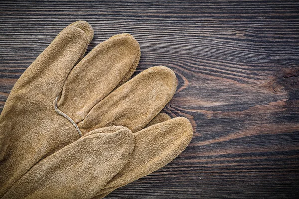 Paar lederne Schutzhandschuhe auf alten Holzbrettern — Stockfoto