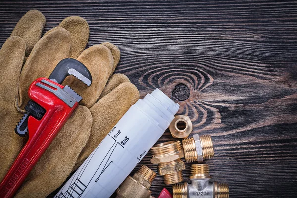 Protective gloves pipe wrench construction drawings brass plumbi — Stock Photo, Image