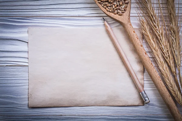 Bunch of wheat-rye ears wooden spoon corn pencil vintage paper o — Stock Photo, Image