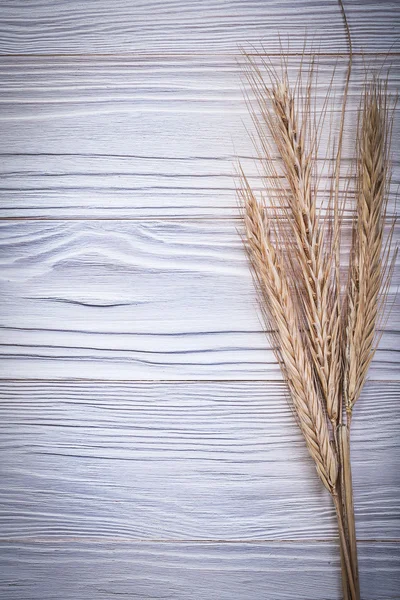 Bunch of golden wheat and rye ears on wooden board top view — Stock Photo, Image