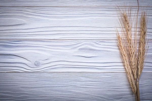 Ramo de trigo maduro y espigas de centeno en tablero de madera vista superior — Foto de Stock