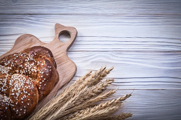 Chopping board bunch of wheat rye ears bread stick on wooden bac — Stock Photo, Image