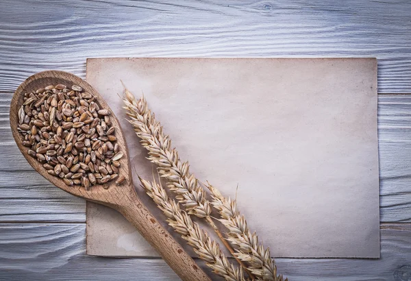 Wheat rye ears corn crop wooden spoon vintage paper sheet on woo — Stock Photo, Image