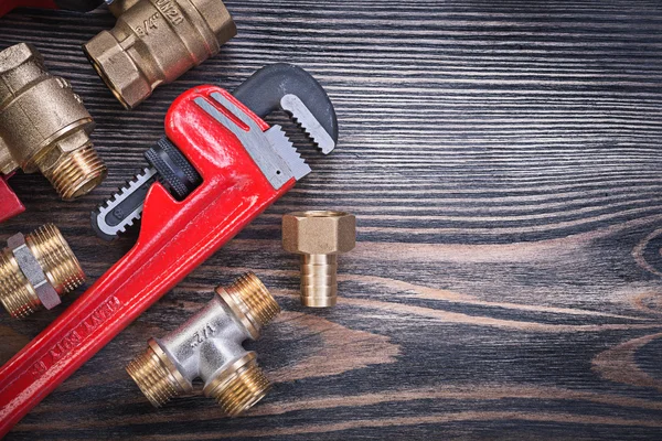 Set of monkey wrench brass connectors on wooden board plumbing c — Stock Photo, Image