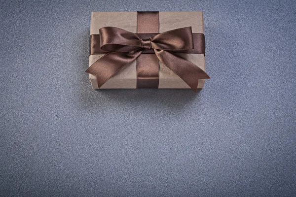 Boxed present in brown wrapping paper on grey background directl — Stock Photo, Image