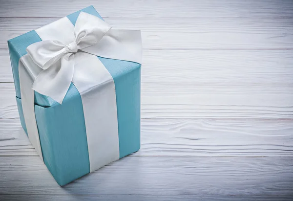 Ingepakte blauwe geschenkdoos op houten plank vieringen concept — Stockfoto