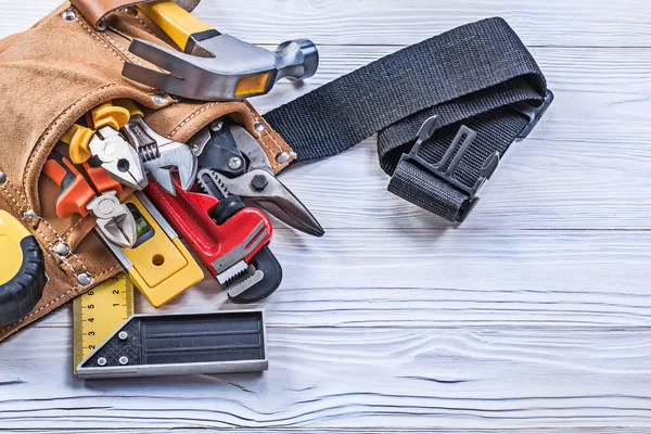 Leather building belt with construction tools on wooden board di — Stock Photo, Image