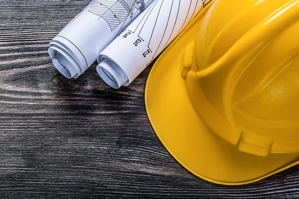 Rolled up construction plans hard hat on wooden board maintenanc — Stock Photo, Image