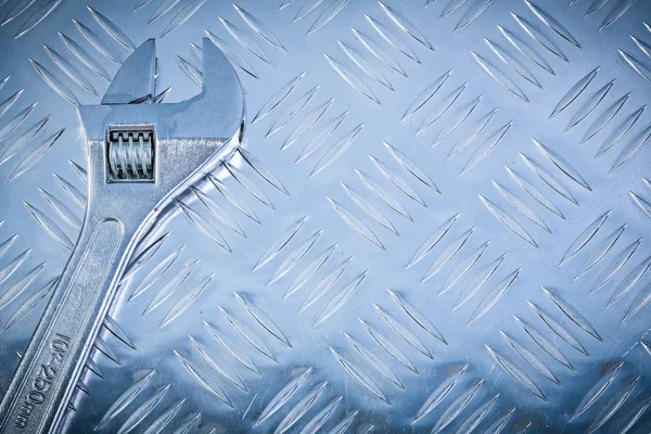 Stainless adjustable key on grooved metal plate construction con — Stock Photo, Image