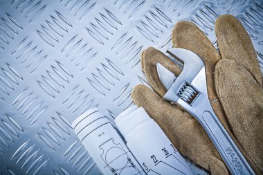 Güvenlik eldivenleri, konstrüksiyon çizimlerini ayarlanabilir anahtar üzerine yuvarlatmış 