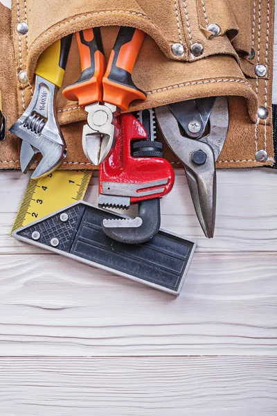 Cinturón de herramientas de cuero con equipo de construcción en tablero de madera — Foto de Stock