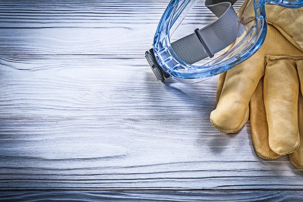 Transparente Schutzbrille Lederhandschuhe auf Holzbrett co — Stockfoto