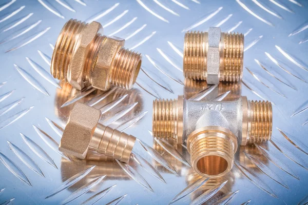 Brass nipple hose connectors equal tee on grooved metal backgrou — Stock Photo, Image