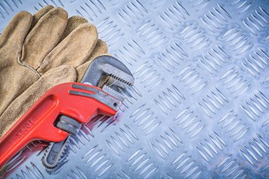 Yivli metal plaka konstruk üzerinde güvenlik eldivenleri boru anahtarı çifti