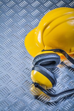 Oluklu metal backgrou üzerinde koruyucu earmuffs bina kask