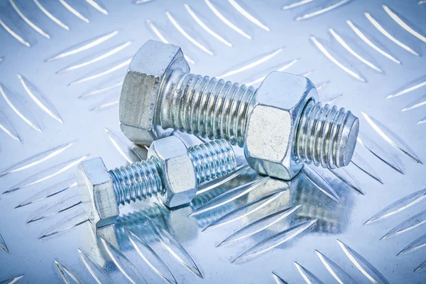 Bolts and construction nut on channeled metal background directl — Stock Photo, Image