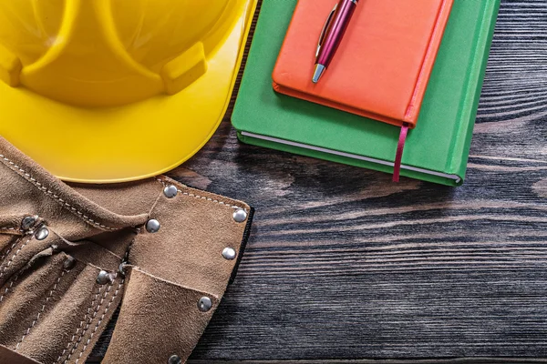 Leather building belt notepads pen protective hard hat on wooden — Stock Photo, Image