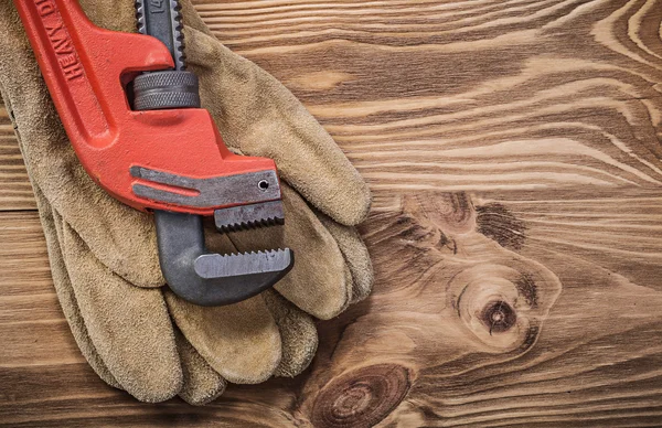 Protective gloves and pipe wrench — Stock Photo, Image