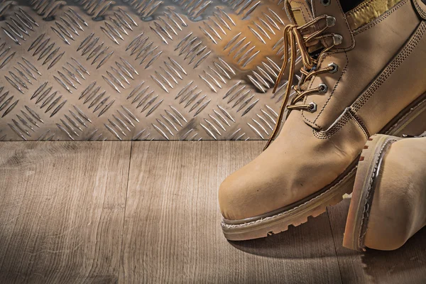 Seguridad impermeable botas de encaje tablero de madera canalizado placa de metal —  Fotos de Stock