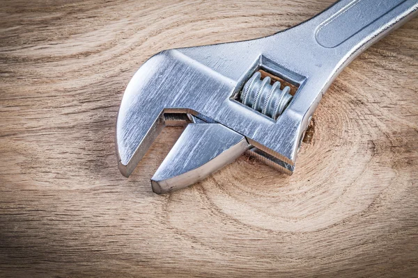 Stainless adjustable spanner on wooden board plumbing concept — Stock Photo, Image