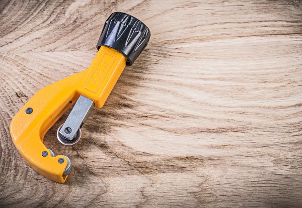 Gele pijp cutter op houten plank bovenaanzicht sanitair concept — Stockfoto