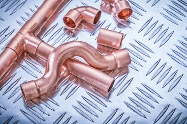 Copper pipe fixtures on corrugated metal sheet plumbing concept clipart