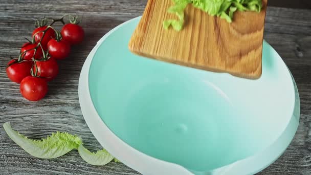 Gehackte Salatblätter Vom Holzschneidebrett Große Blaue Schüssel Gießen — Stockvideo