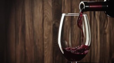 - Şarap. Şarap kadehiyle şarap şişesinden dökülen kırmızı şarap eski ahşap arka planda ağır çekimde.