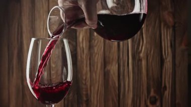 Kırmızı şarap kadehten şarap bardağına dökülüyor.