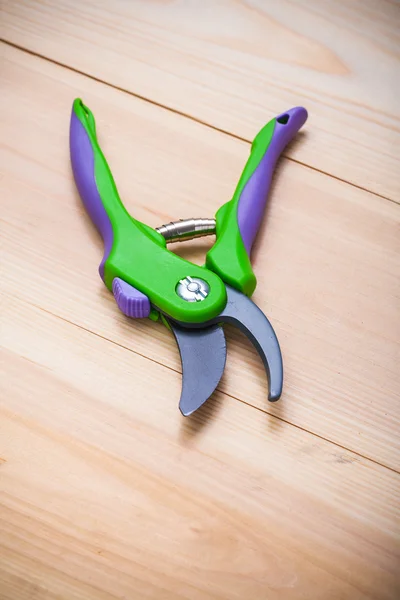 Secateurs on wooden board — Stock Photo, Image