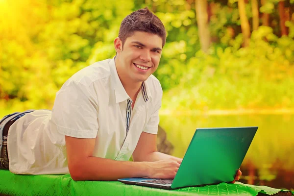 一个年轻的微笑笔记本电脑 instagram 颜色的男人 — 图库照片
